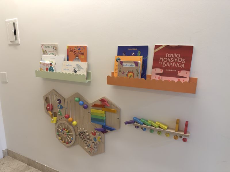 Parede com livros infantis e painel de atividades