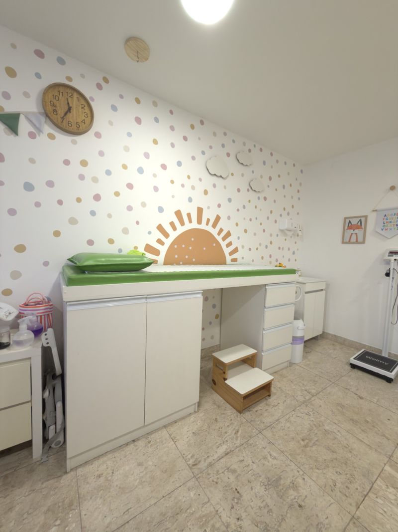 Maca infantil diante da parede com sol e bolinhas coloridas